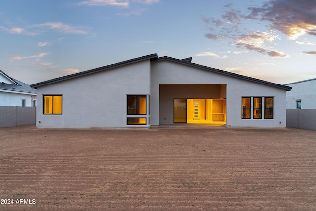 view of back house at dusk