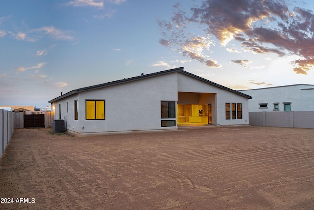 back house at dusk with central air condition unit