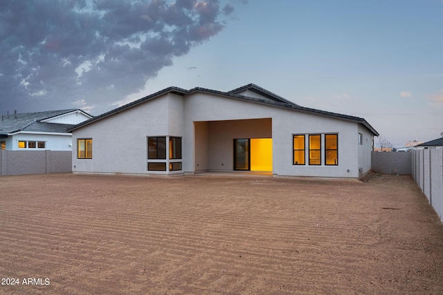 view of back house at dusk