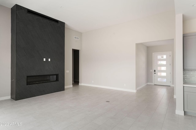 unfurnished living room featuring a fireplace and light tile patterned flooring