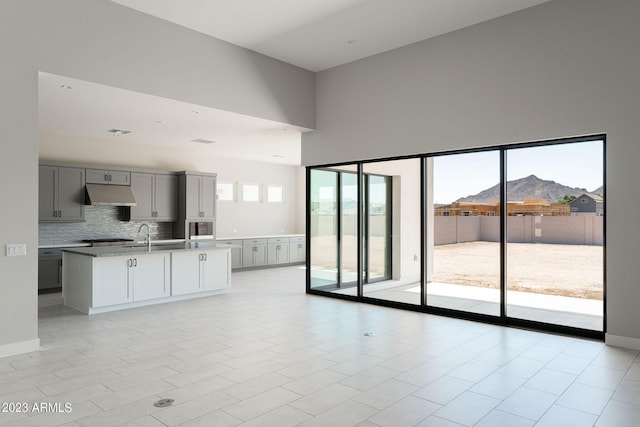 unfurnished living room with a mountain view, a healthy amount of sunlight, and a high ceiling