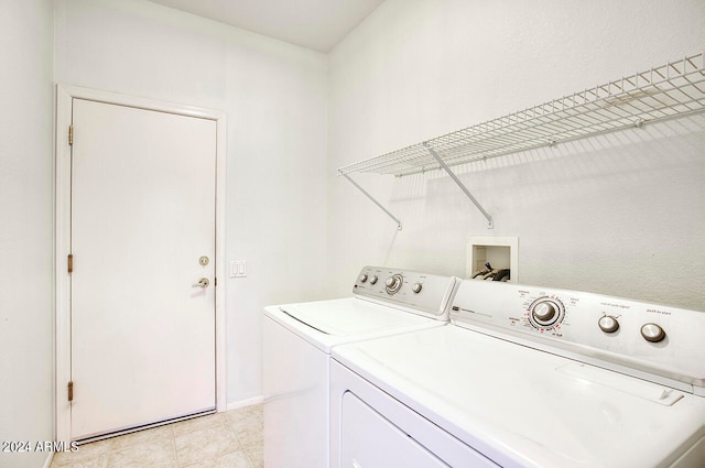 clothes washing area featuring light tile patterned flooring and washer and dryer