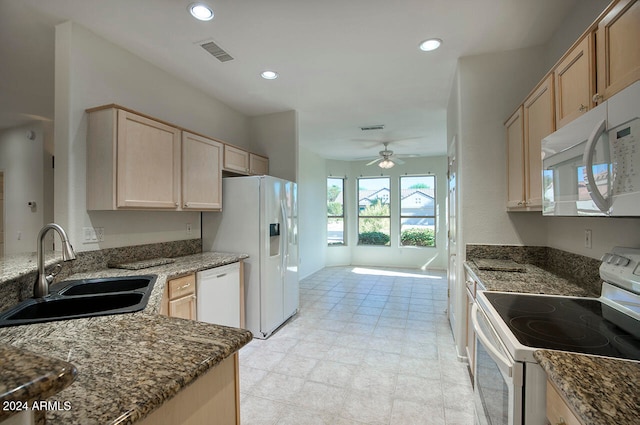 kitchen with ceiling fan, light brown cabinets, dark stone countertops, white appliances, and sink