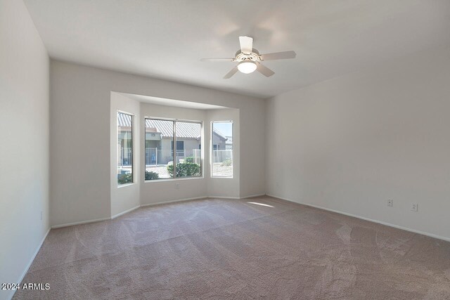 spare room with light carpet and ceiling fan