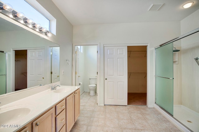 bathroom featuring vanity, toilet, an enclosed shower, and tile patterned floors