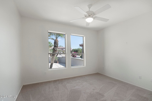 empty room with ceiling fan and light carpet