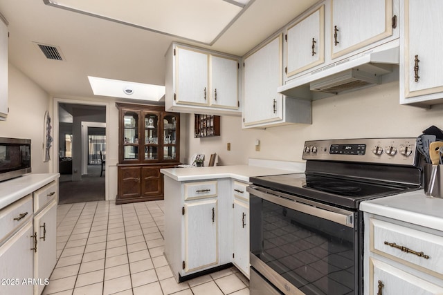 kitchen with stainless steel appliances, kitchen peninsula, white cabinets, and light tile patterned flooring