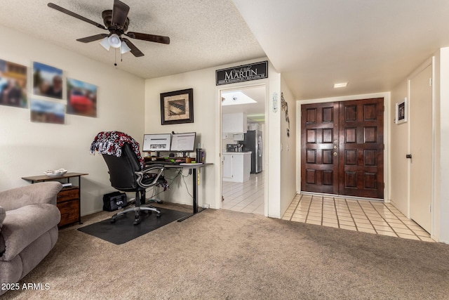 carpeted home office with ceiling fan and a textured ceiling