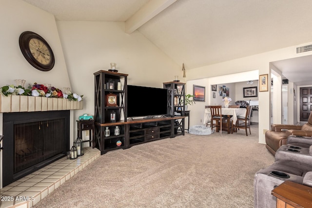 living room featuring lofted ceiling with beams, a fireplace, and carpet floors