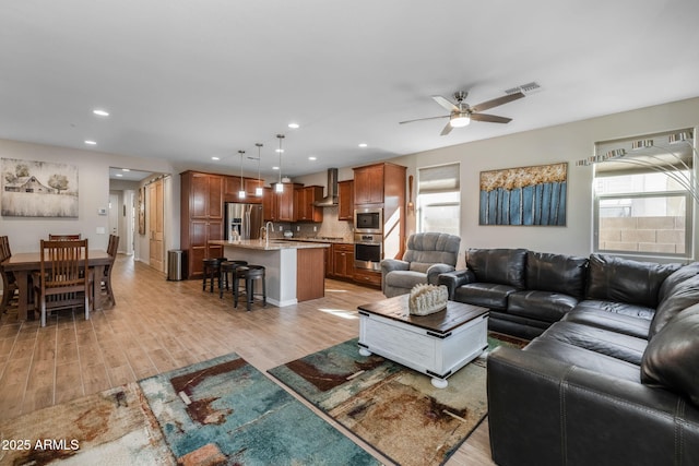 living room featuring light hardwood / wood-style floors and ceiling fan