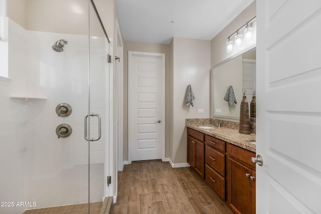 bathroom with vanity, an enclosed shower, and hardwood / wood-style floors