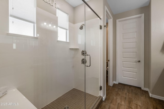 bathroom with wood-type flooring and a shower with door