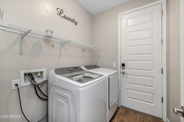 clothes washing area with washing machine and clothes dryer and dark hardwood / wood-style floors