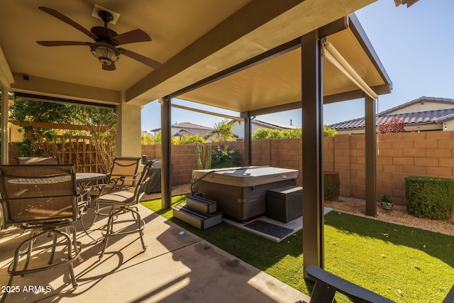 view of patio with ceiling fan and a hot tub