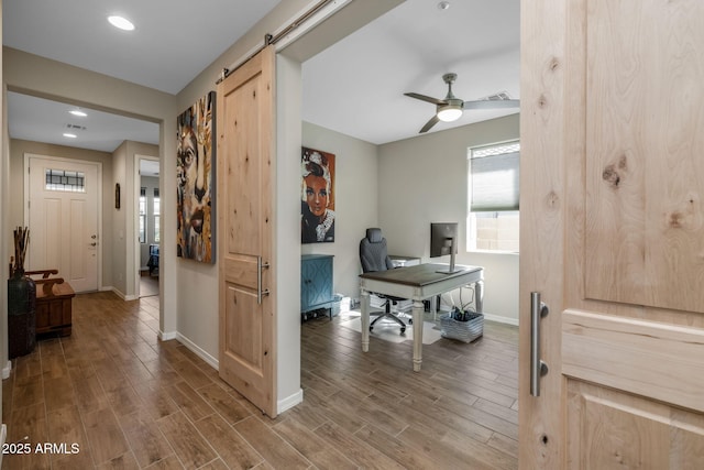 office area featuring hardwood / wood-style floors, a barn door, and ceiling fan