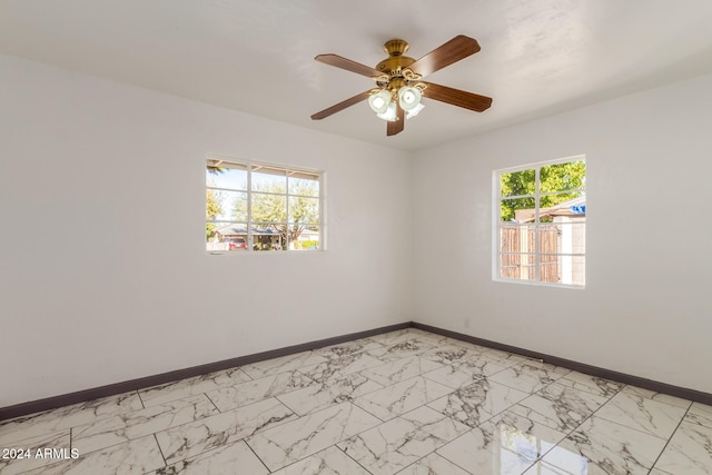 spare room with ceiling fan and a healthy amount of sunlight