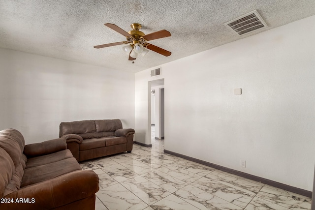 living room with ceiling fan and a textured ceiling