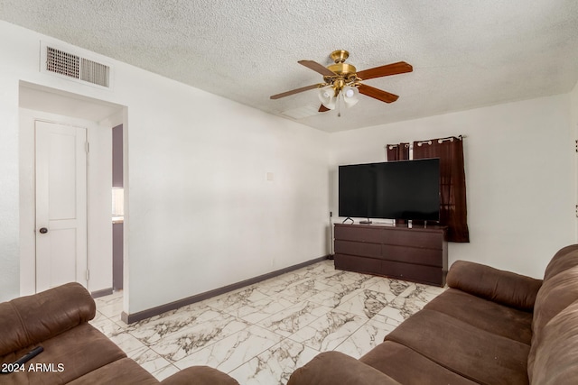 living room featuring ceiling fan and a textured ceiling