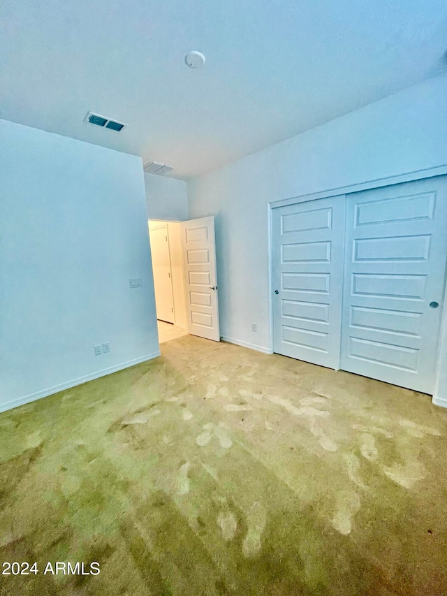 unfurnished bedroom with a closet and carpet