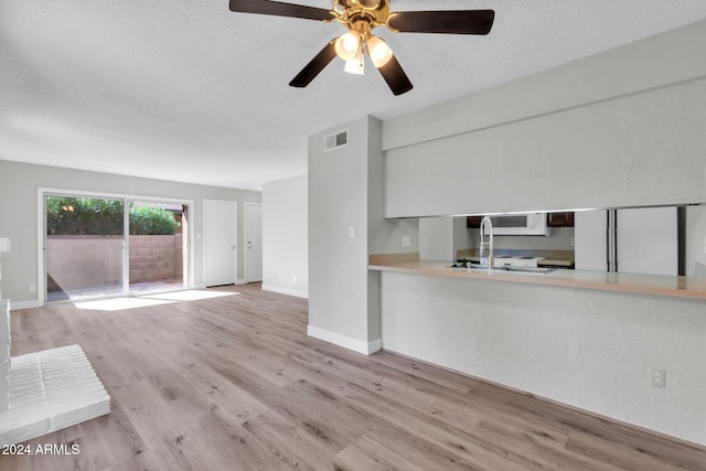 unfurnished living room featuring a textured ceiling and light wood-type flooring