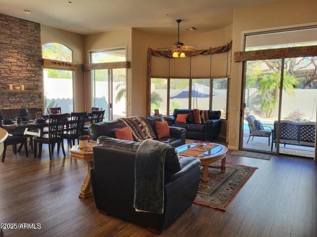 living room with a ceiling fan and dark wood-type flooring