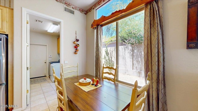 dining area with visible vents, washer / dryer, and light tile patterned flooring