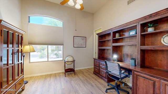 office featuring baseboards, a ceiling fan, and light wood-style floors