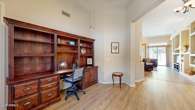 office area with visible vents, built in study area, baseboards, and light wood-type flooring