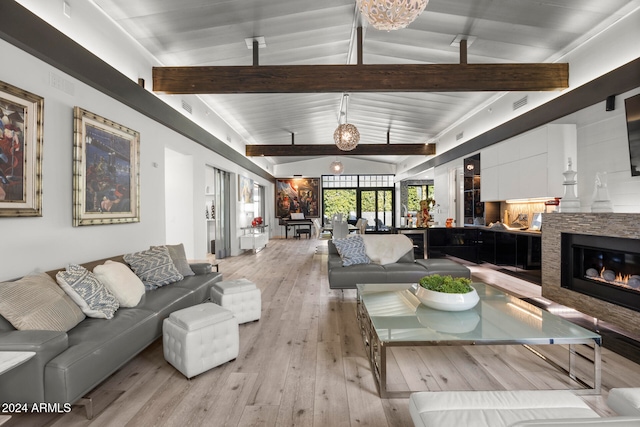 living room with vaulted ceiling with beams and light hardwood / wood-style floors