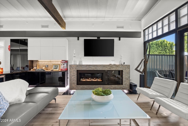 living room featuring beam ceiling and light hardwood / wood-style floors