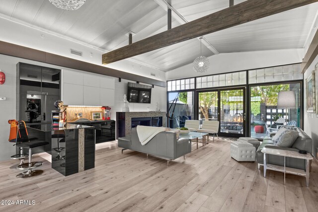 living room featuring a notable chandelier, beam ceiling, light hardwood / wood-style floors, and high vaulted ceiling