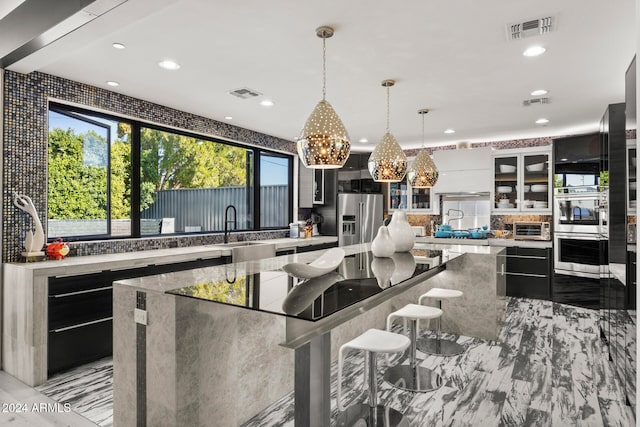 kitchen featuring hanging light fixtures, a spacious island, sink, and appliances with stainless steel finishes