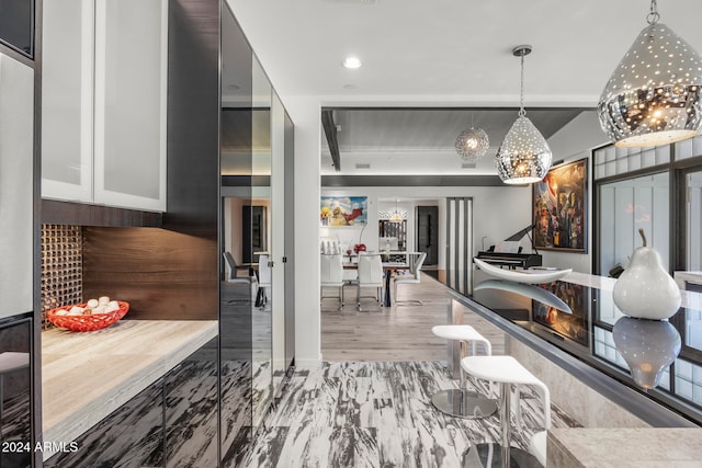 interior space with hardwood / wood-style floors, pendant lighting, and white cabinetry