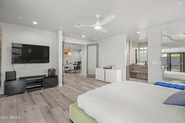 bedroom with ceiling fan, ensuite bathroom, and light wood-type flooring