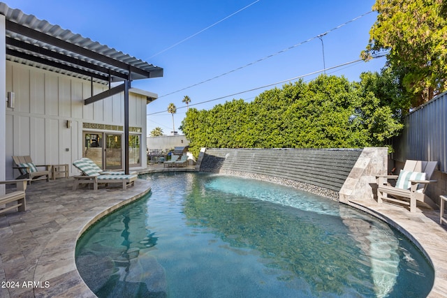 view of swimming pool with pool water feature and a patio area