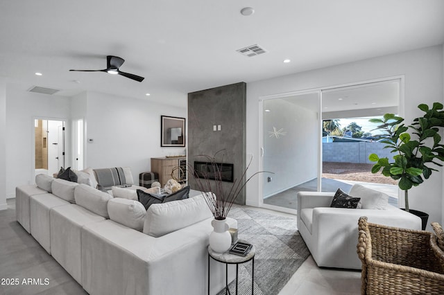 living room with ceiling fan and a large fireplace