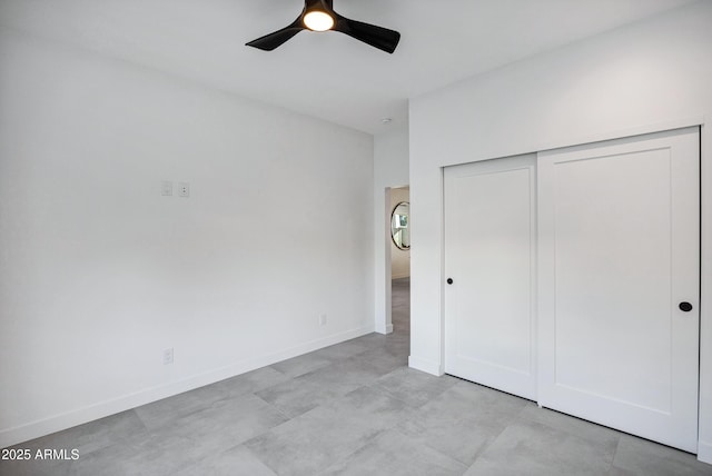 unfurnished bedroom with ceiling fan and a closet