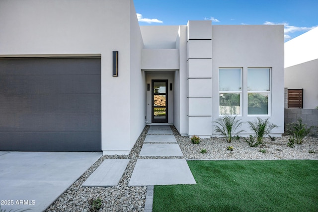 property entrance with a garage and a yard