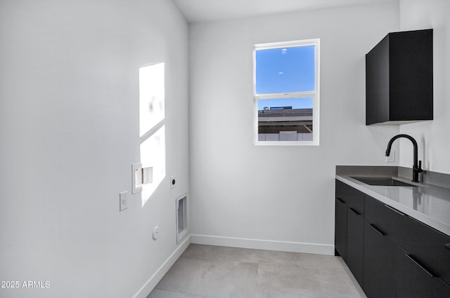 clothes washing area with cabinets, electric dryer hookup, hookup for a gas dryer, and sink