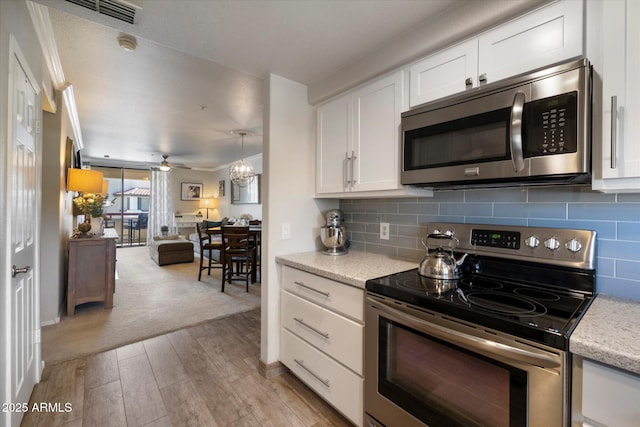 750 E Northern Ave Unit 2143, Phoenix, AZ 85020 - kitchen featuring appliances with stainless steel finishes, light wood finished floors, white cabinetry, tasteful backsplash, and open floor plan