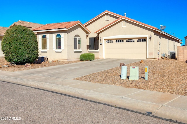 view of front of property with central AC and a garage