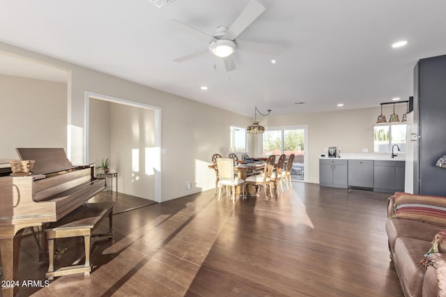 living room featuring dark hardwood / wood-style floors, ceiling fan, and sink