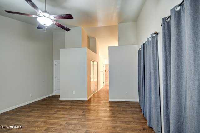 interior space with a towering ceiling, dark hardwood / wood-style floors, and ceiling fan