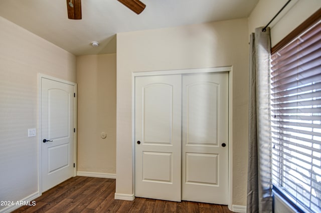 unfurnished bedroom featuring a closet, ceiling fan, and dark hardwood / wood-style flooring