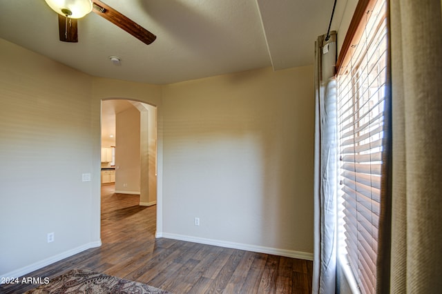 empty room featuring ceiling fan and dark hardwood / wood-style flooring