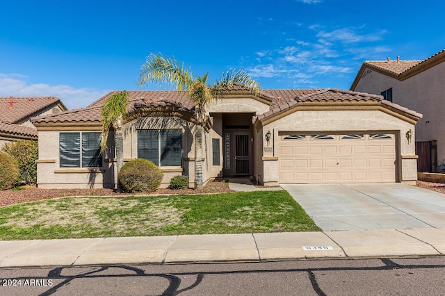 mediterranean / spanish house with a front lawn and a garage