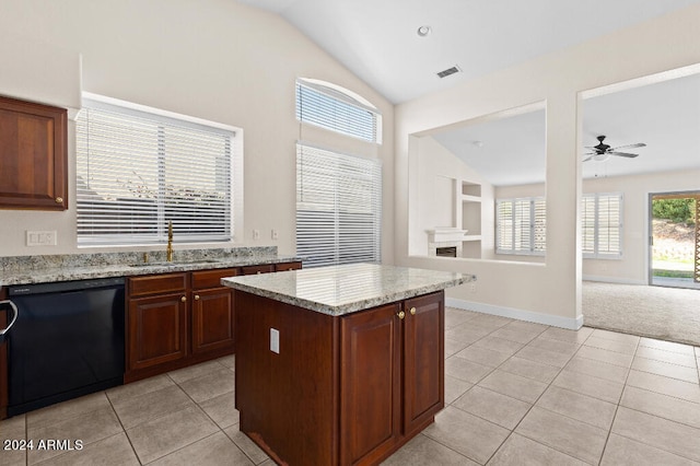 kitchen with light tile flooring, light stone counters, a kitchen island, ceiling fan, and dishwasher