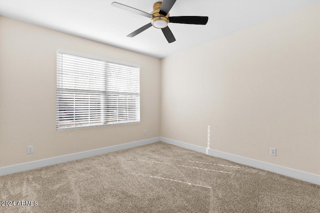 spare room with ceiling fan and light carpet