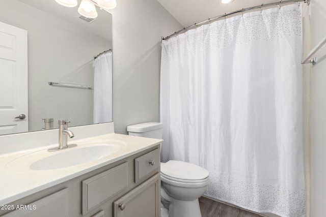 full bathroom with visible vents, a shower with shower curtain, toilet, vanity, and wood finished floors