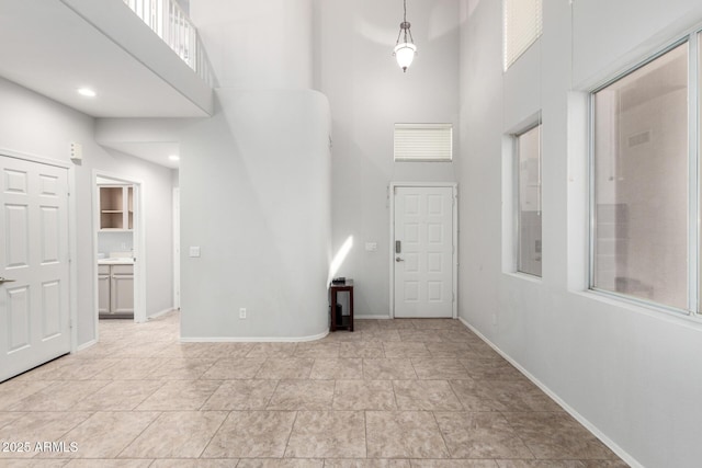 entrance foyer with a towering ceiling and baseboards